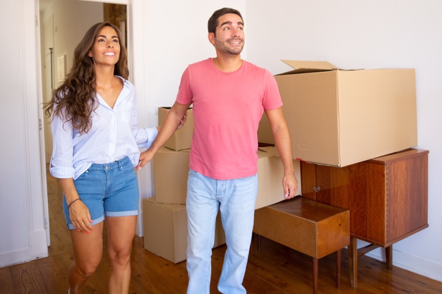 happy-excited-young-couple-looking-their-new-apartment-with-carton-boxes-furniture-smiling-talking_74855-9978